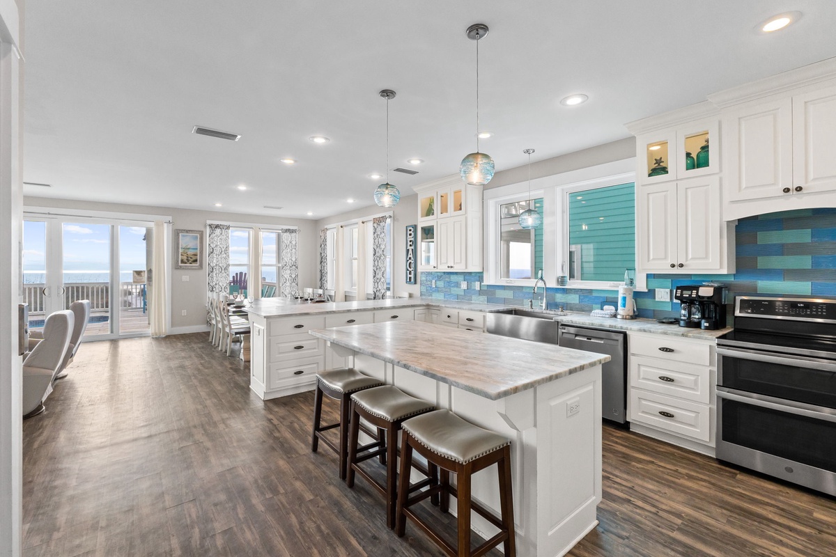 Your gourmet kitchen features stunning blue tile backsplash, marble counters, and ocean views for memorable meal prep moments.