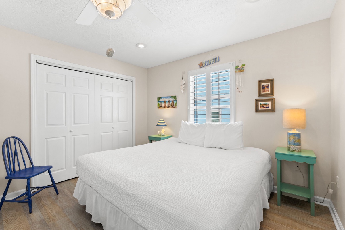 Your serene bedroom sanctuary features crisp white linens, charming coastal decor, and warm lighting for peaceful nights.
