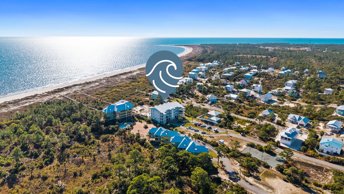 Stunning aerial view of a coastal community nestled between pristine beaches and lush forest, showcasing the natural beauty of the surrounding area.