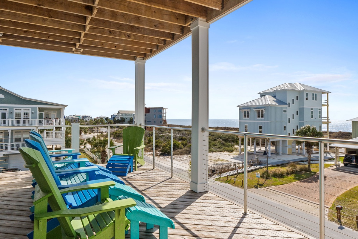 Unwind in colorful Adirondack chairs on your covered deck, where ocean breezes and neighborhood views create the perfect backdrop for morning coffee or evening relaxation.