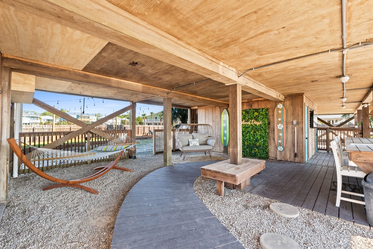 Thoughtfully designed outdoor living continues beneath the home, with inviting lounge areas and a hammock made for slow afternoons.