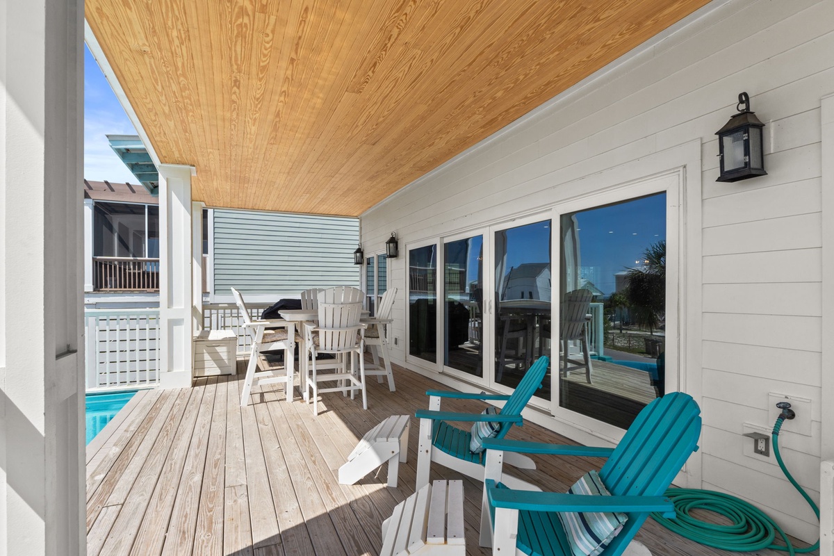 Relax on your private deck with turquoise Adirondack chairs overlooking the pool, perfect for morning coffee or evening unwind.