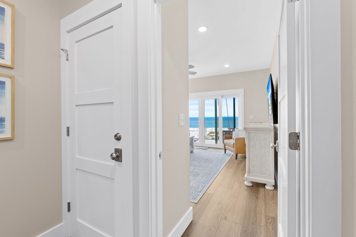 Step into your coastal sanctuary where gleaming hardwood floors lead to stunning ocean views through floor-to-ceiling windows.