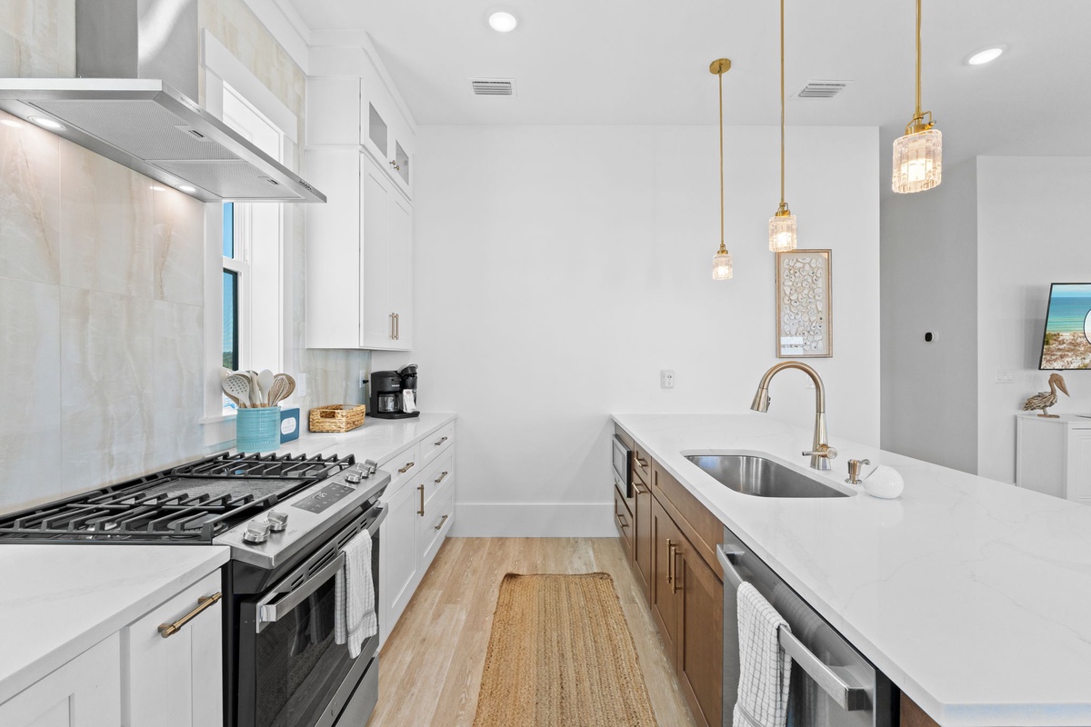 Your modern kitchen awaits with gleaming quartz counters, professional gas range, and elegant pendant lighting for memorable meal preparation.