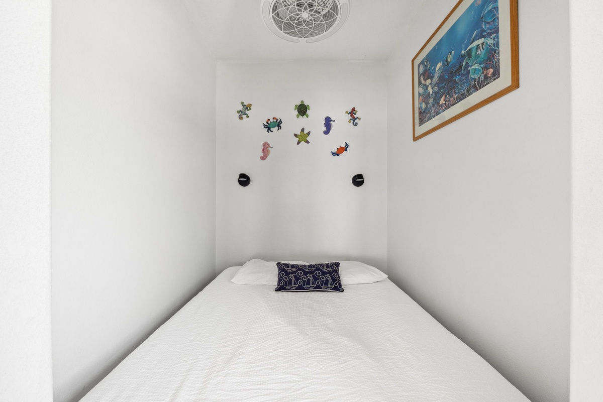 Your cozy nook awaits—crisp linens, cheerful ocean art, and playful sea creatures create a peaceful retreat perfect for restful nights by the coast.