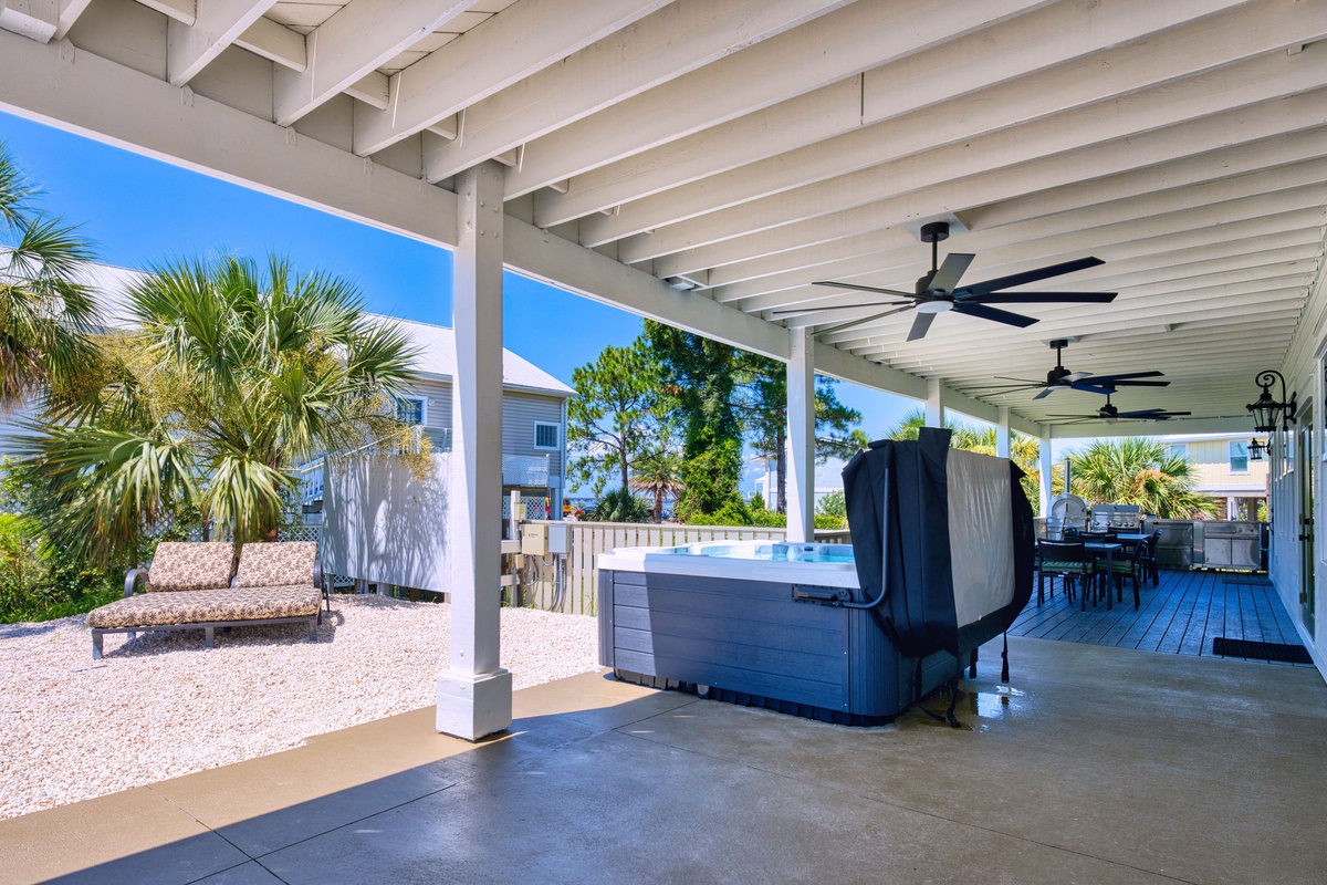Unwind in your private hot tub beneath the shaded pergola, where ceiling fans cool you as you soak and tropical breezes drift through palm-lined grounds.