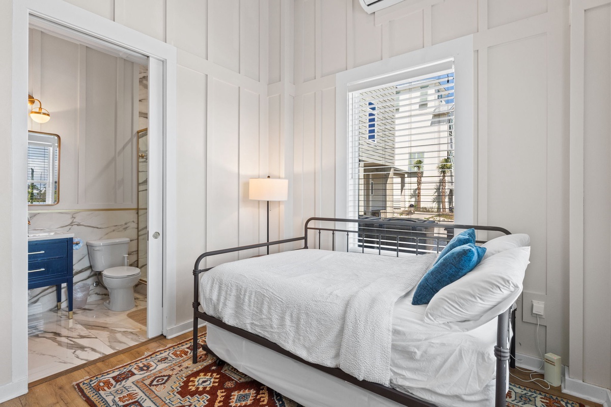 Your cozy bedroom features a stylish metal-frame bed with soft linens, perfect for peaceful nights after exploring the city.