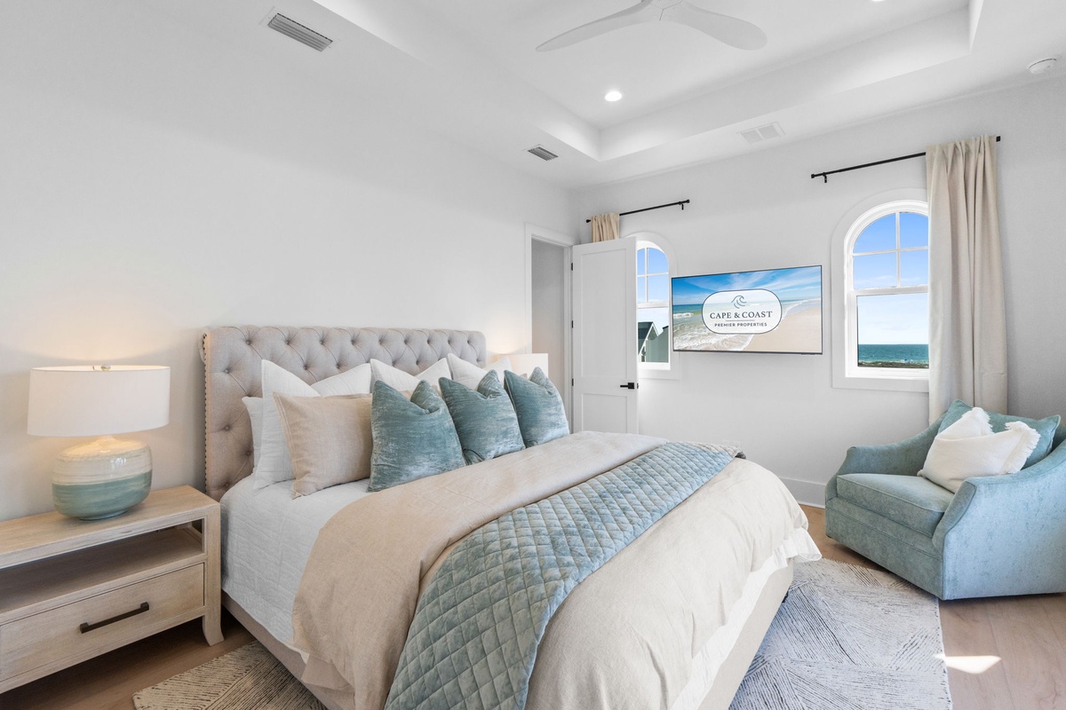 Sink into coastal serenity with ocean views from your bed and luxurious tufted headboard in this elegant retreat.