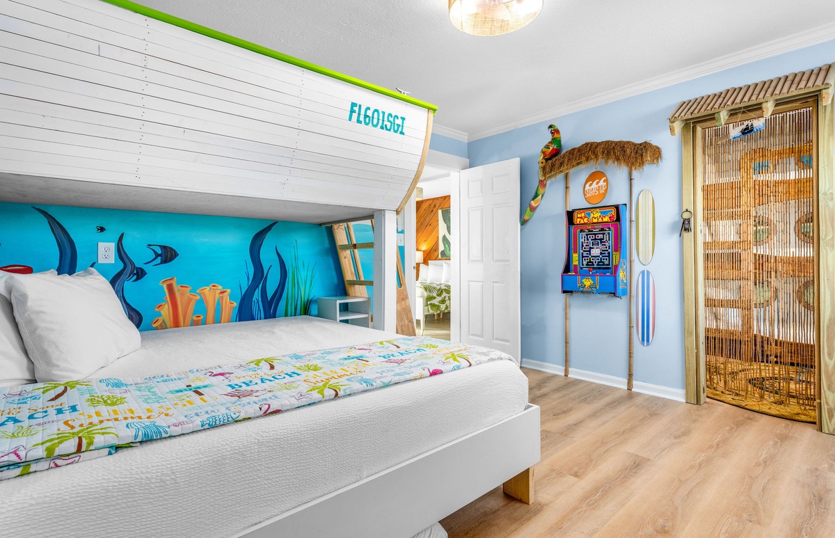 Your kids will love this ocean-themed bedroom with custom bunk beds, arcade games, and tropical bamboo accents.