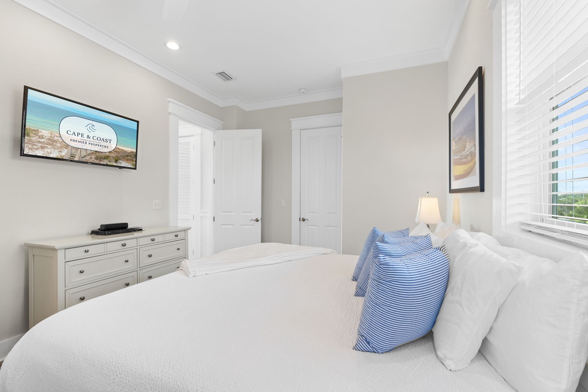 Sink into soft linens and coastal comfort in your serene bedroom, complete with modern amenities and peaceful vibes for restful nights.