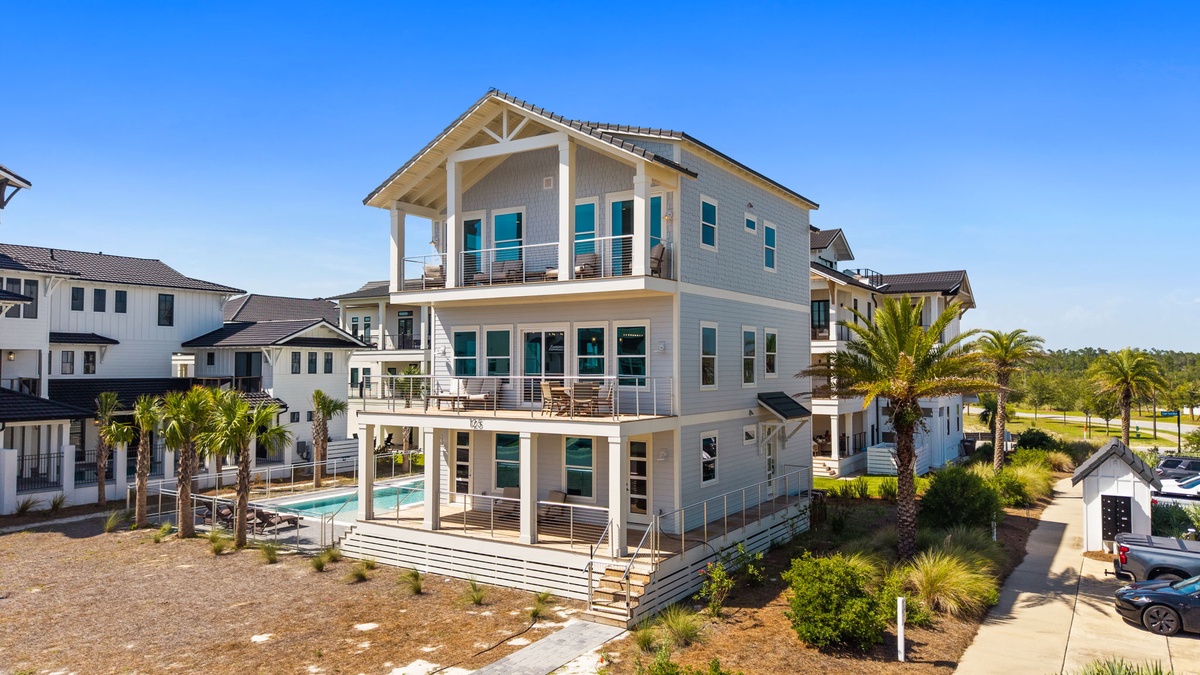 A modern three-story coastal retreat with spacious balconies and a sparkling private pool, set in a sunny neighborhood near golf and natural landscapes.