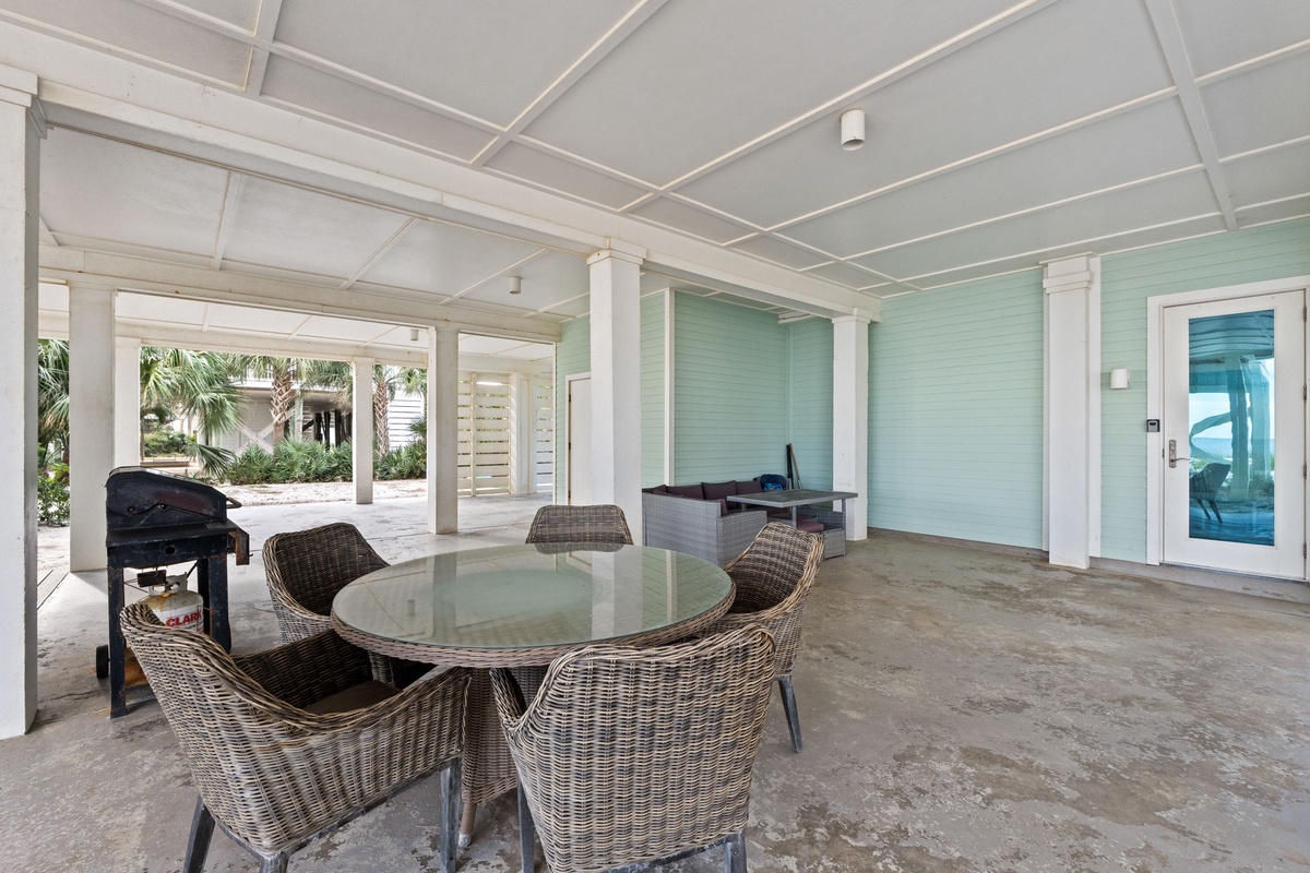 Relax in your covered patio with wicker dining for six, grill ready for outdoor cooking, and soothing aqua walls creating perfect tropical ambiance.