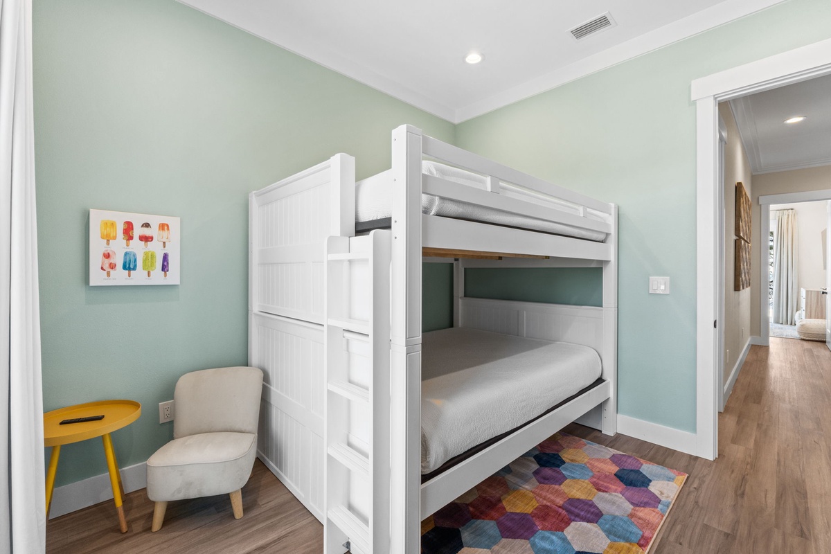 Your kids will love this cheerful bedroom with comfy bunk beds, a cozy reading chair, and playful artwork creating the perfect space for bedtime stories.