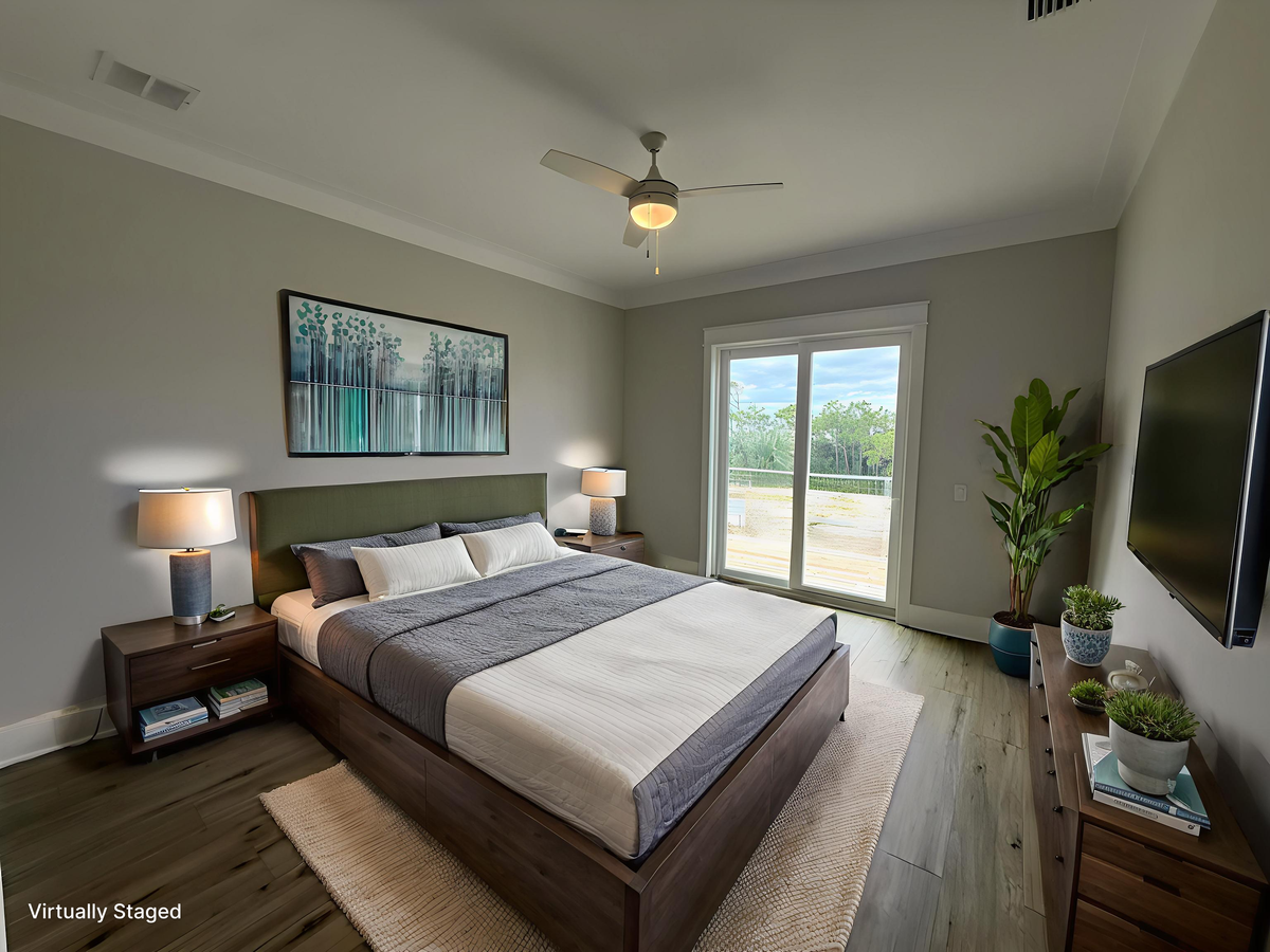 Relax in your peaceful bedroom sanctuary with a comfy bed, gentle ceiling fan, and patio doors opening to natural light.