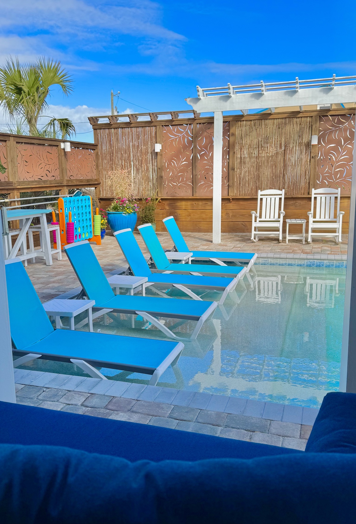 Soak up the sun on your private poolside terrace, where vibrant blue loungers await your afternoon relaxation session.