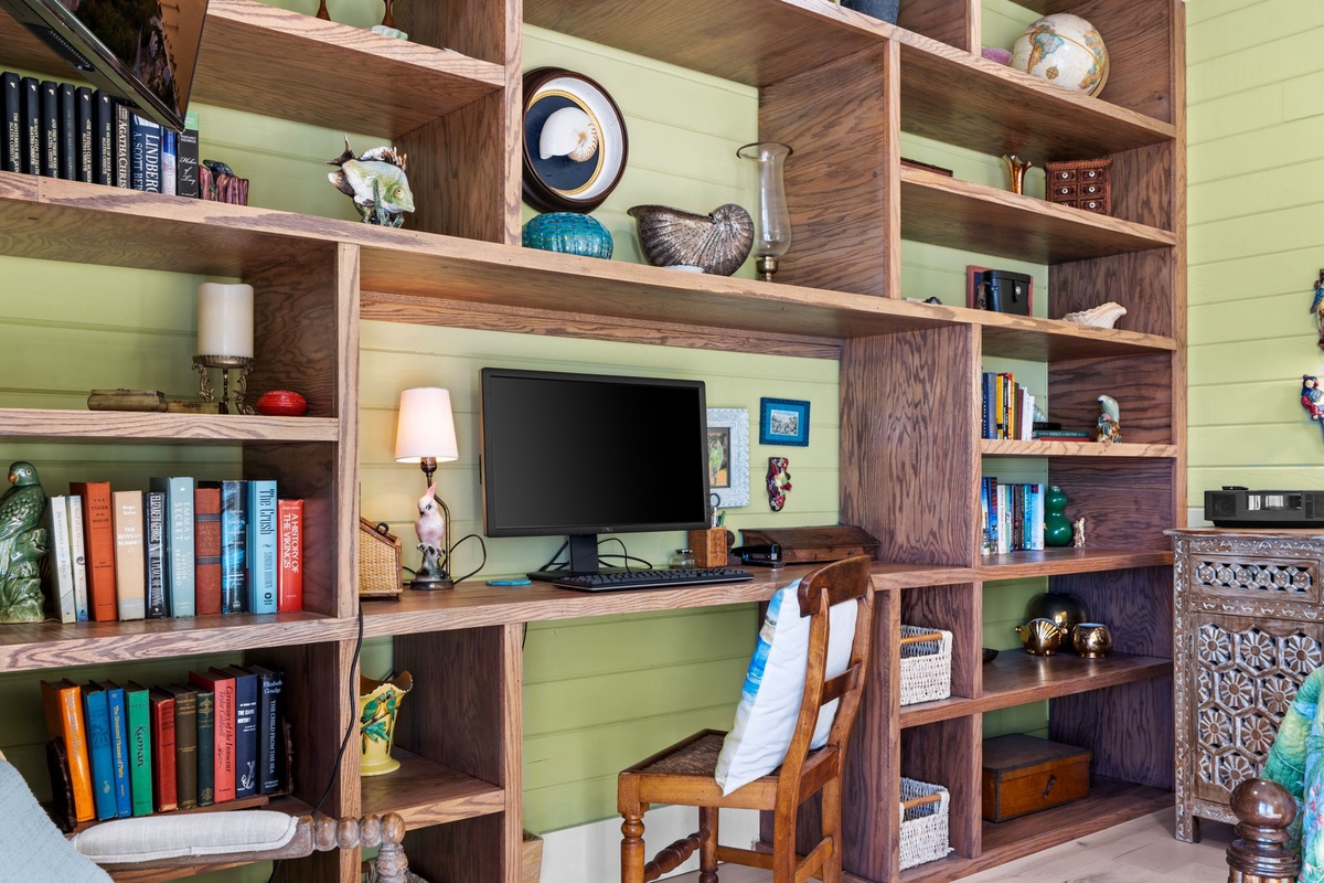 Your private workspace features custom walnut shelving filled with books, a dedicated desk area, and cozy reading nooks.