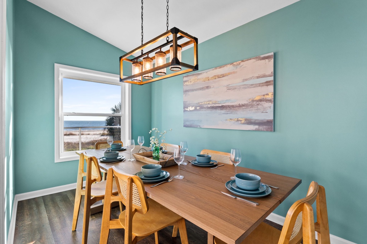 Gather around your elegant dining table where ocean views through the window create the perfect backdrop for memorable meals.