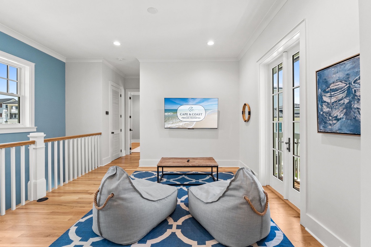 Sink into oversized bean bags and enjoy your favorite shows in this bright, airy living space designed with coastal charm and relaxation in mind.