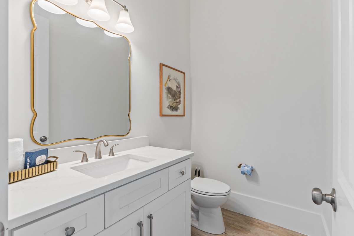 Freshen up in your stylish powder room featuring elegant gold accents, pristine marble countertops, and thoughtful amenities for your comfort.
