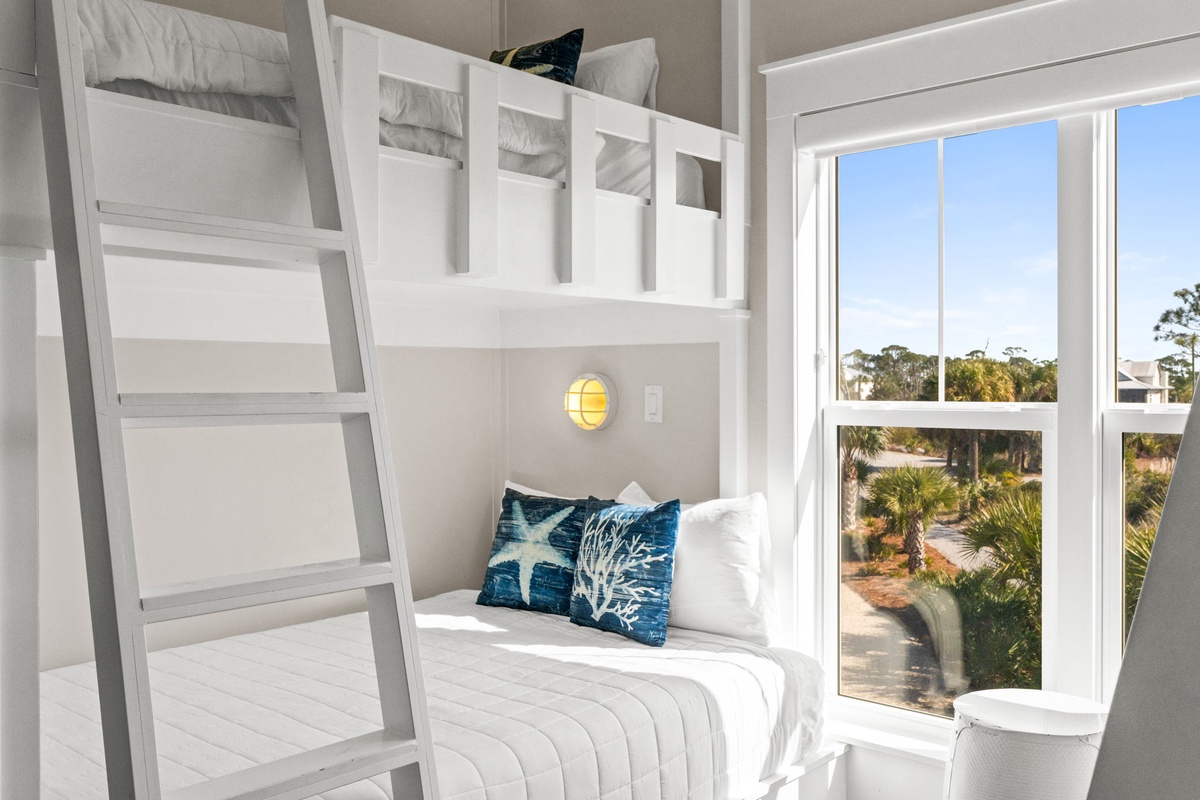 Drift off in your cozy bunk bed with ocean-themed pillows and warm reading light as tropical views fill the windows.