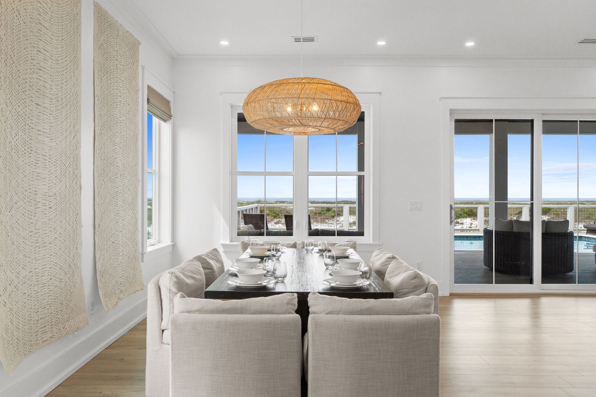 Gather around your elegant dining table beneath a stunning woven pendant light. Large windows and patio doors frame peaceful views and flood your space with natural light.