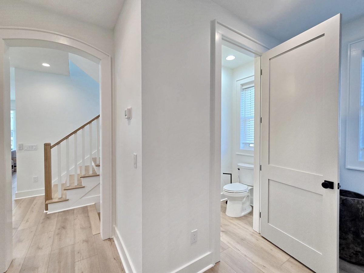 Step into this bright, modern hallway where clean lines and warm wood floors create a welcoming flow throughout your space.