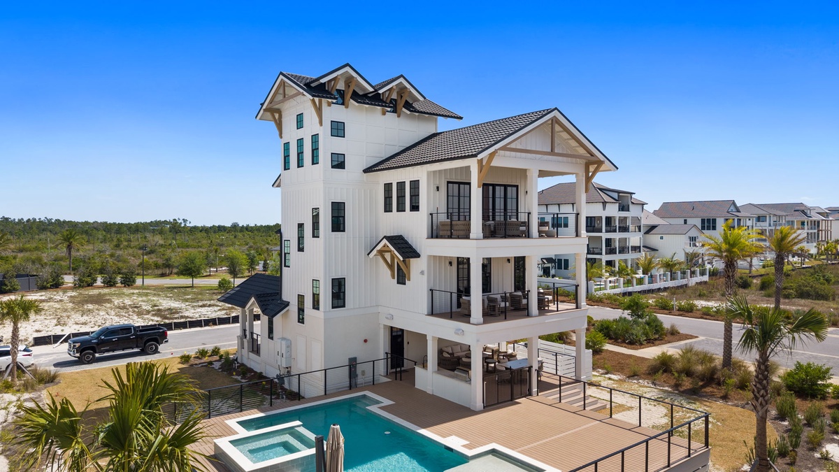 Modern coastal vacation home featuring multiple levels of covered balconies and a sparkling pool in a beachside community.
