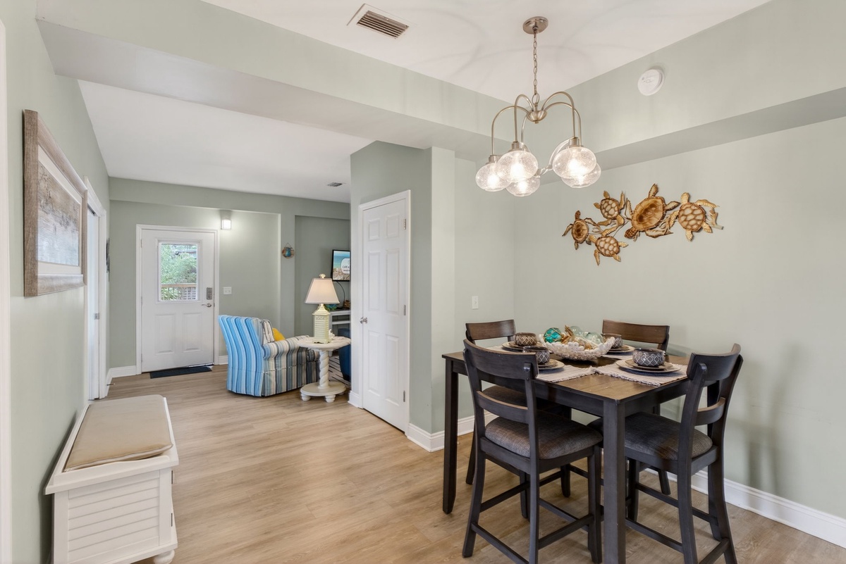 Gather around your elegant dining table where coastal turtle art and warm pendant lighting create the perfect atmosphere for memorable meals.