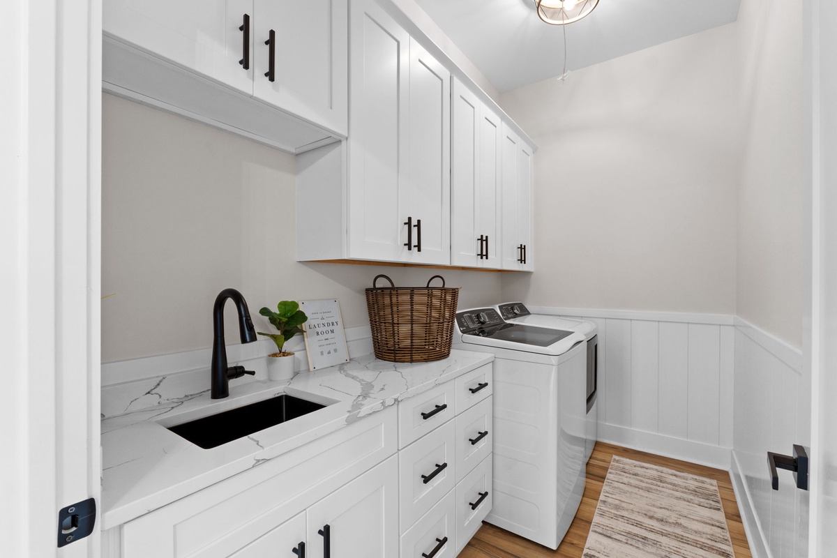Bright, clean laundry space makes chores a breeze. You'll love the marble countertop for folding, ample cabinet storage, and convenient sink—all designed to keep your space tidy and efficient.