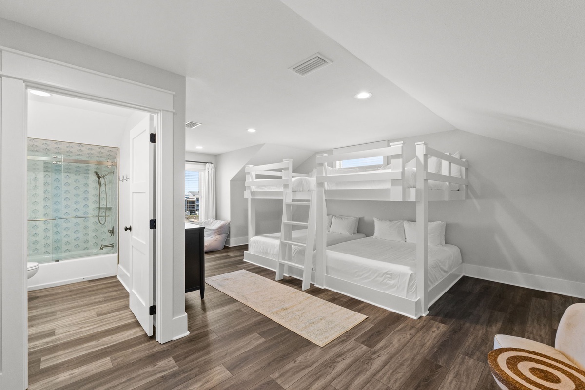 Climb into crisp white bunks in your bright, serene sleeping space. Wood-style floors warm the room, while the private bath awaits just steps away.