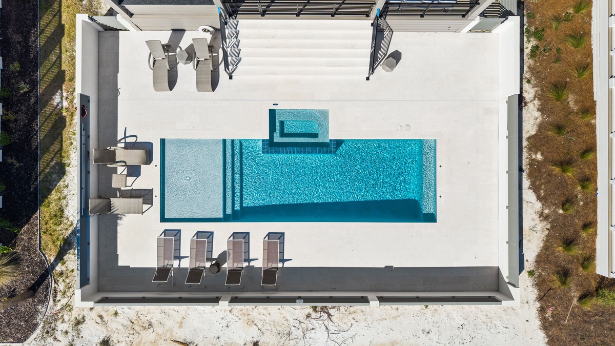 Aerial view of the modern property featuring a stunning swimming pool with elegant outdoor seating areas and contemporary architecture.