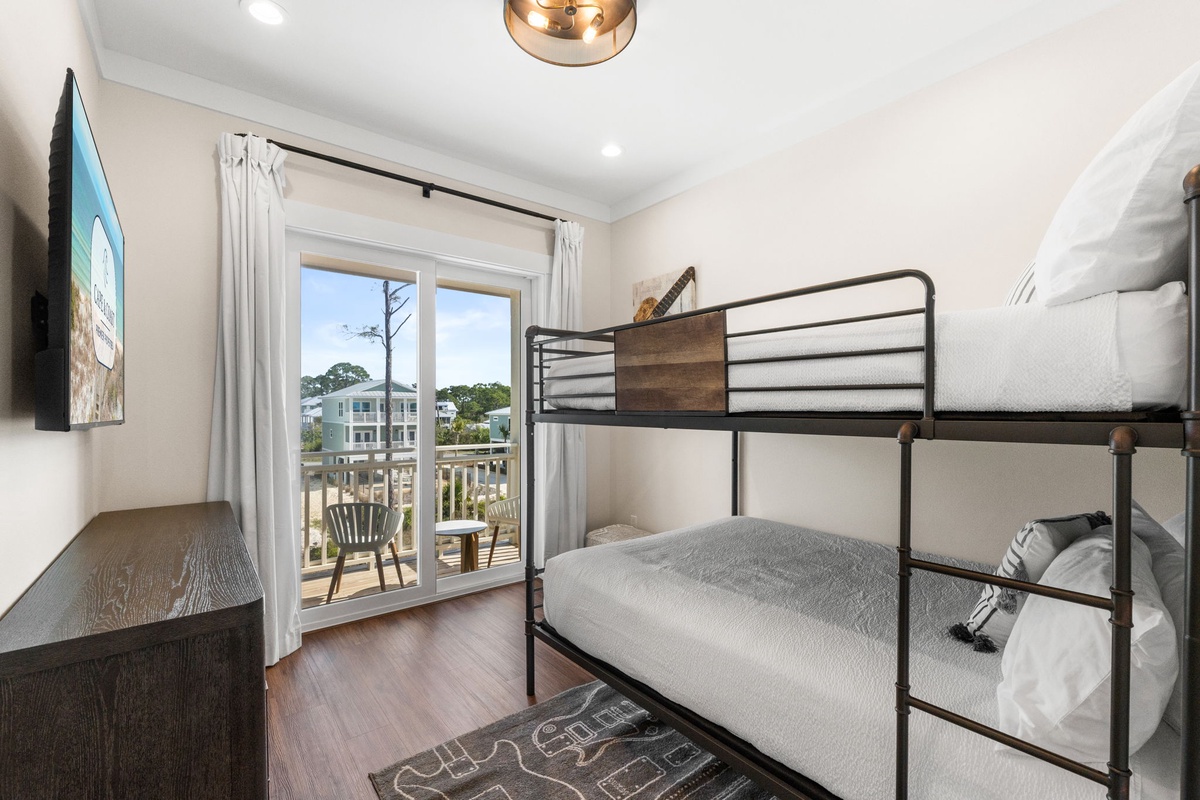 Sleep soundly in your bunk bed retreat with private balcony access and peaceful neighborhood views through floor-to-ceiling windows.