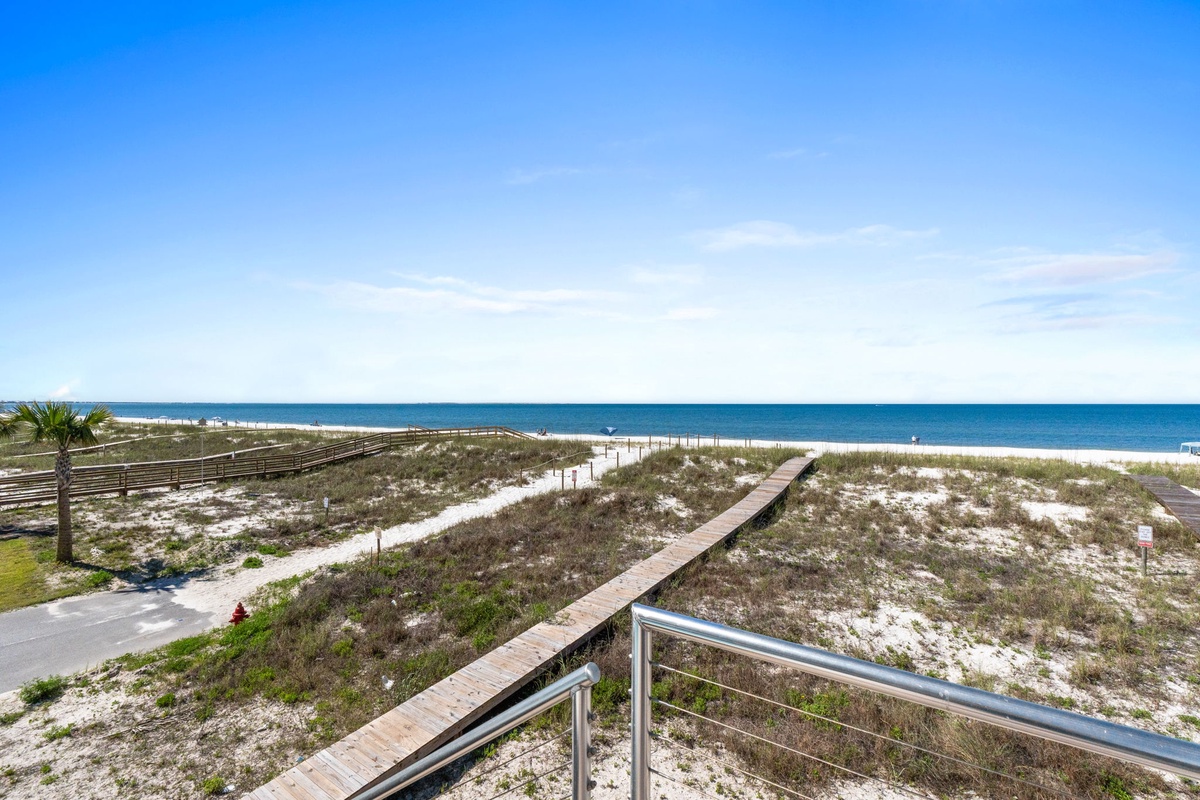 Direct beach access via a wooden boardwalk leads you to pristine white sand and turquoise waters, perfect for your coastal getaway.