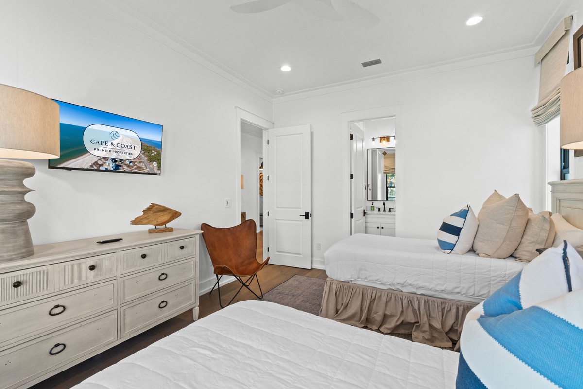 Rest easy in your coastal-themed bedroom with twin beds, nautical accents, and modern amenities for a perfect night's sleep.