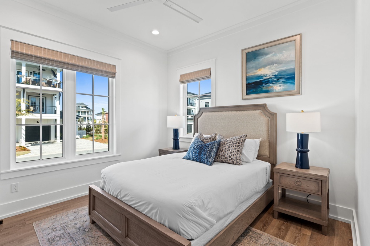 Drift off to sleep in your peaceful bedroom, where ocean artwork and soft linens create a serene coastal retreat.