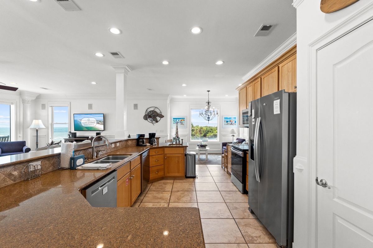 Your fully equipped kitchen with ocean views invites you to prepare meals while soaking in stunning coastal scenery through expansive windows, blending cooking convenience with beachfront bliss.