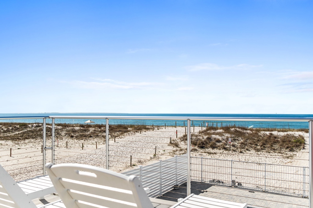 Beachfront terrace with stunning ocean views and direct beach access via boardwalk.