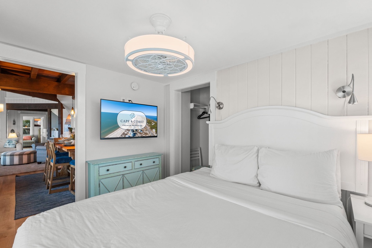 Drift off in comfort with crisp linens and a coastal vibe that whispers relaxation, complete with ceiling fan and charming reading lights to help you unwind.