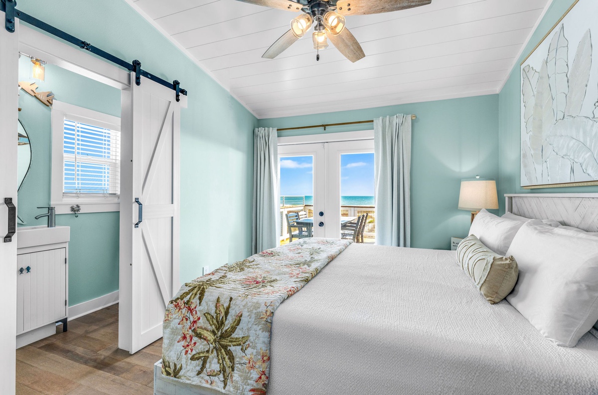 Wake up to stunning ocean views from your coastal bedroom, where calming mint walls and tropical touches create your perfect beach retreat.