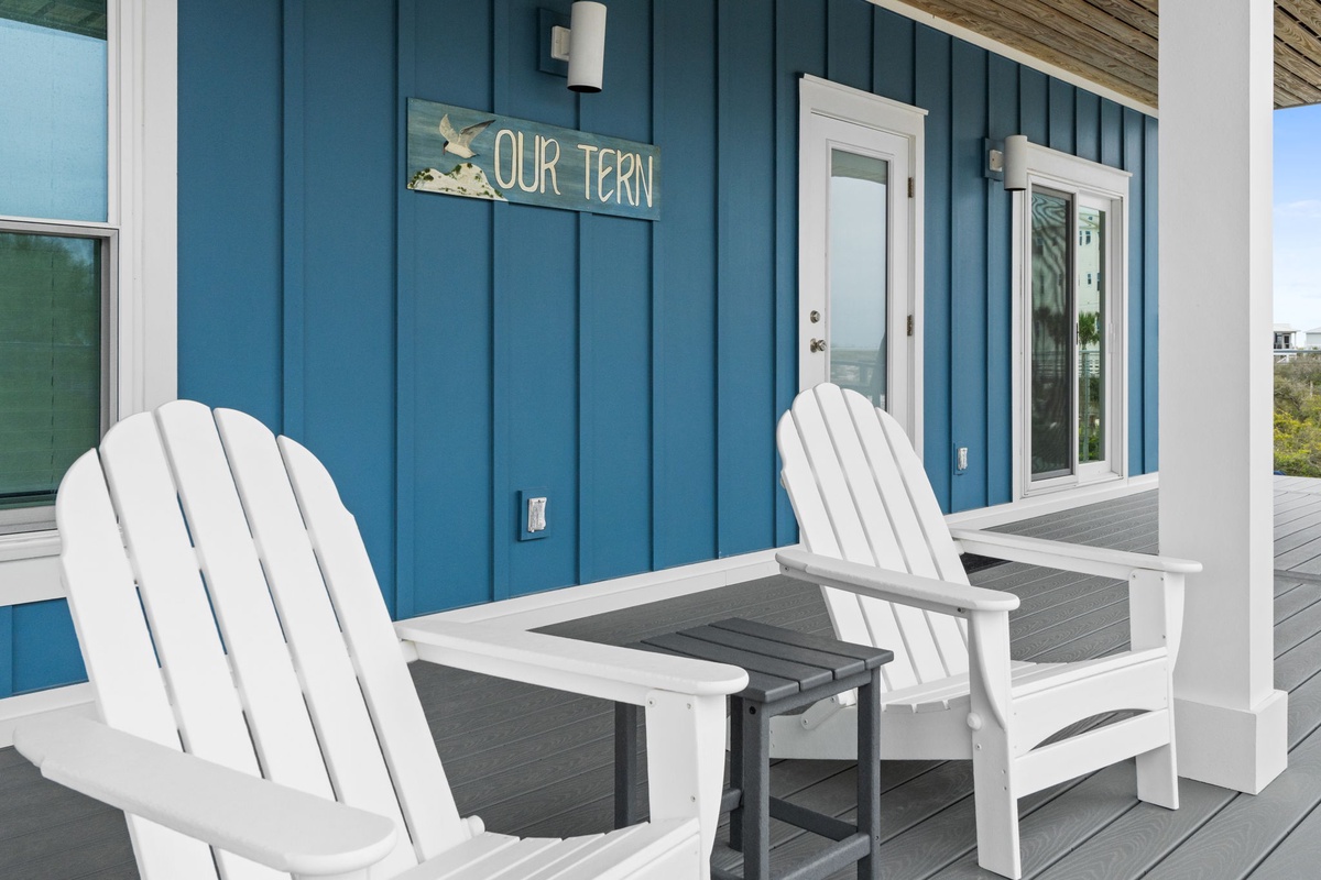 Settle into classic Adirondack chairs on your private deck, where coastal charm meets comfort under the welcoming 'Our Tern' sign.