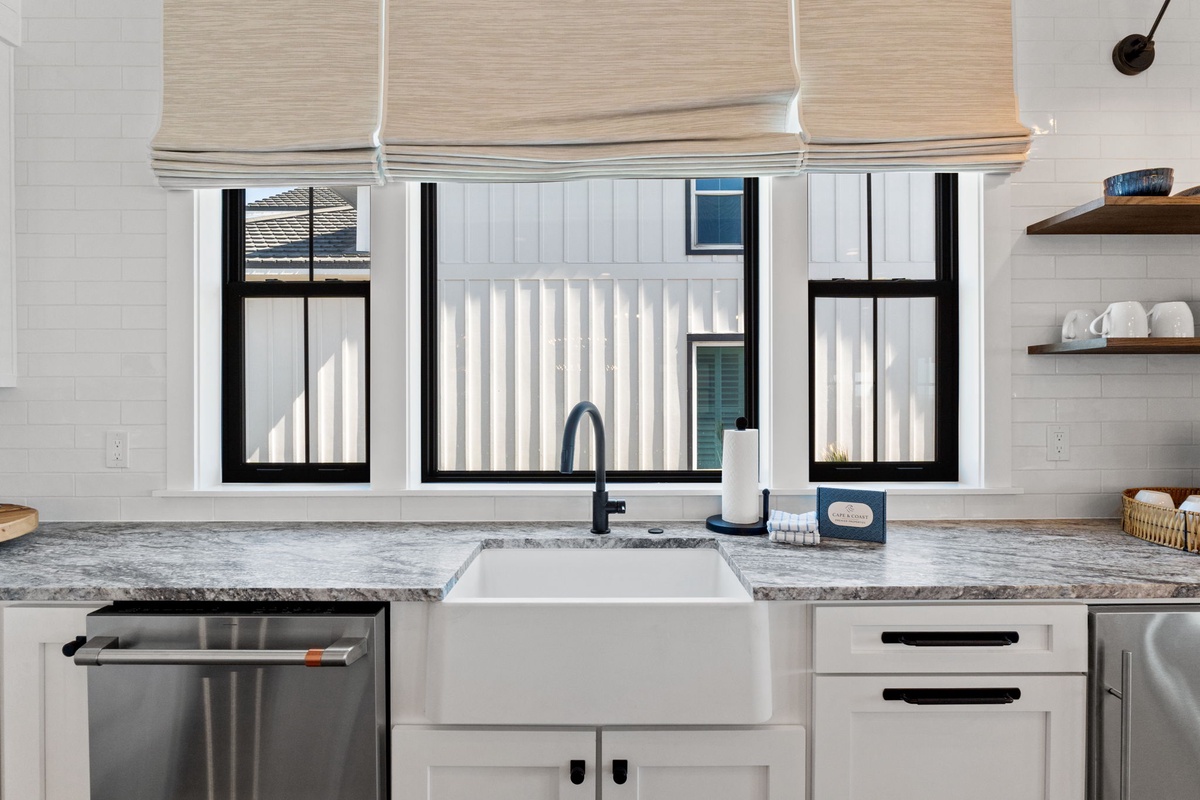 Your gourmet kitchen features a farmhouse sink with black fixtures and granite countertops for cooking memorable meals.