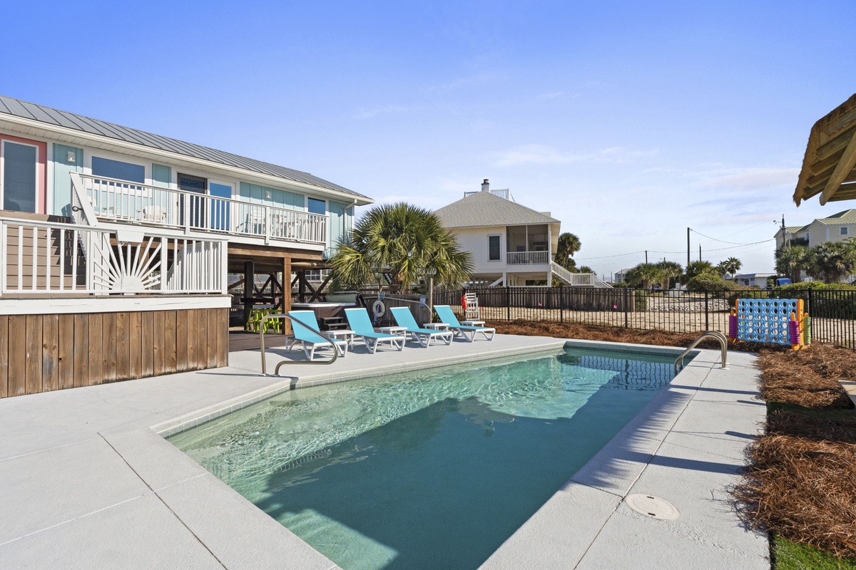 A private pool with ample lounge seating creates the perfect setting for sunny coastal days.