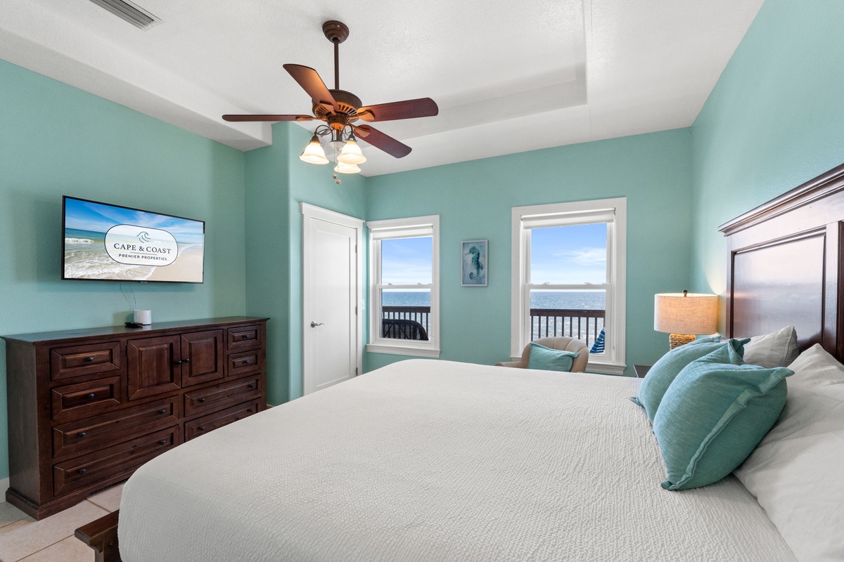 Wake refreshed in this serene coastal bedroom where aqua walls and ocean breezes create your perfect retreat. Sink into crisp linens while glimpsing endless water views through dual windows.