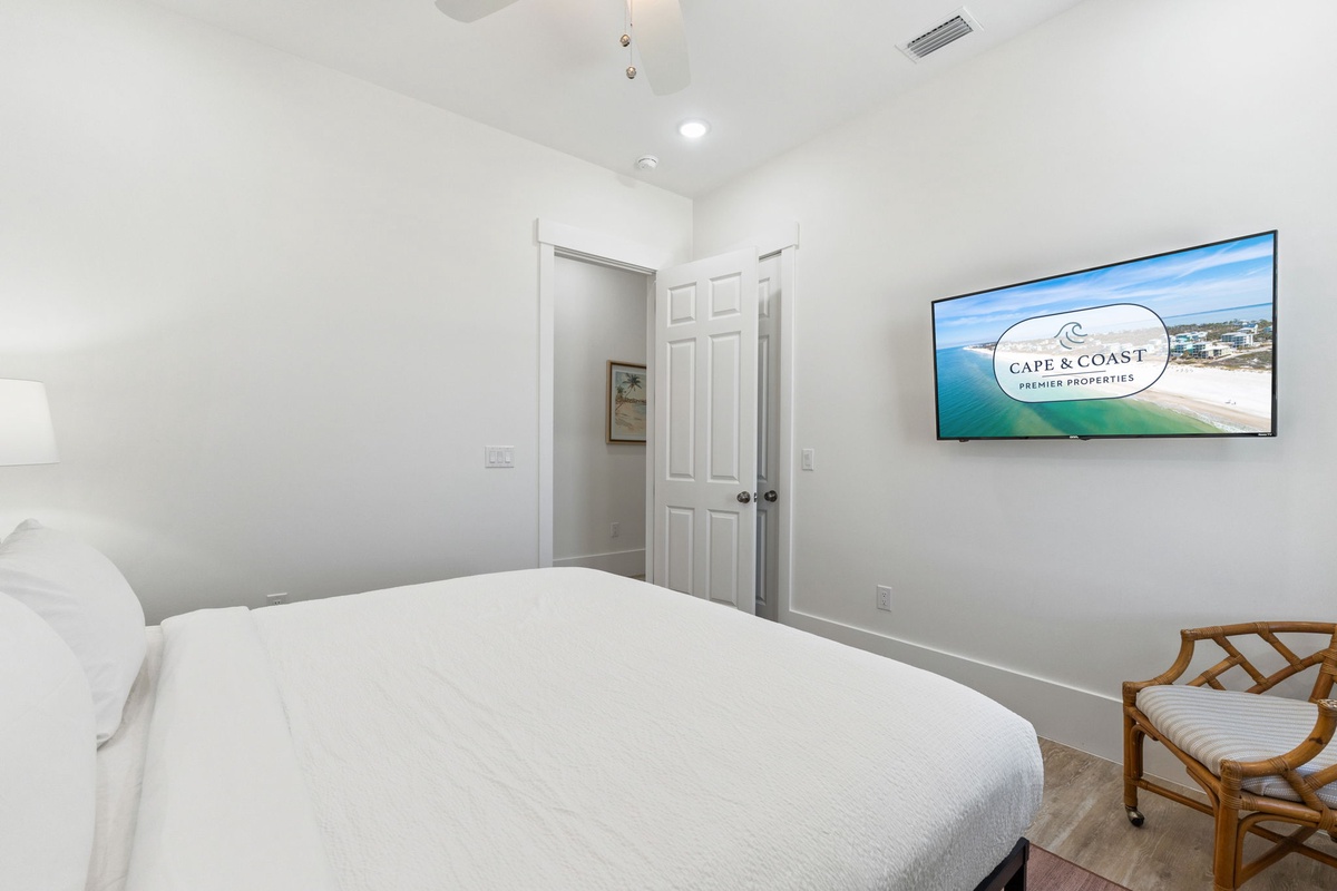 Sink into crisp white linens in your serene bedroom, where coastal views on the wall-mounted TV help you unwind after beach days.