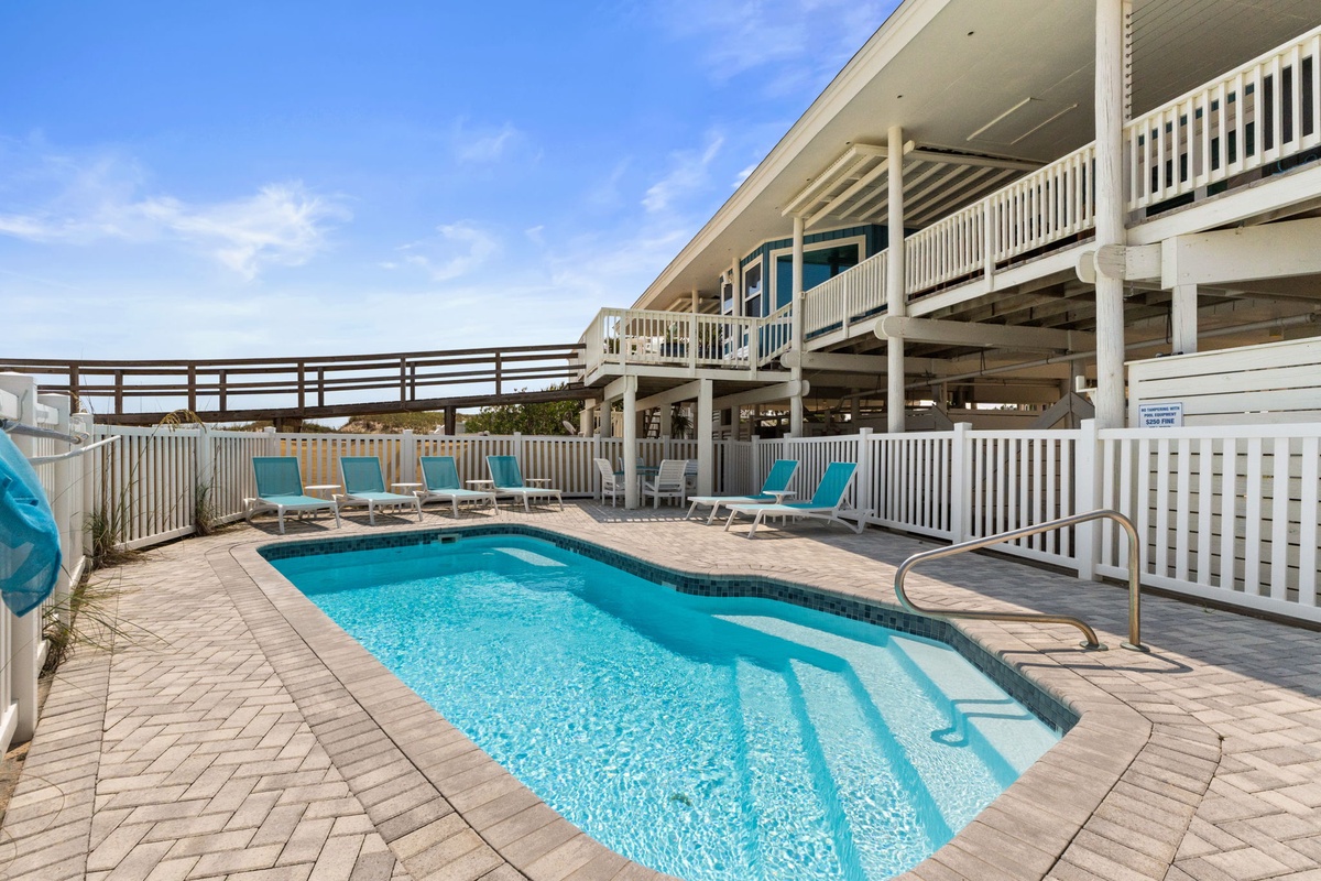 Private beachside oasis with sparkling pool, turquoise loungers, and elegant paver decking. Step outside to soak up sun-drenched days in your own resort-style retreat.