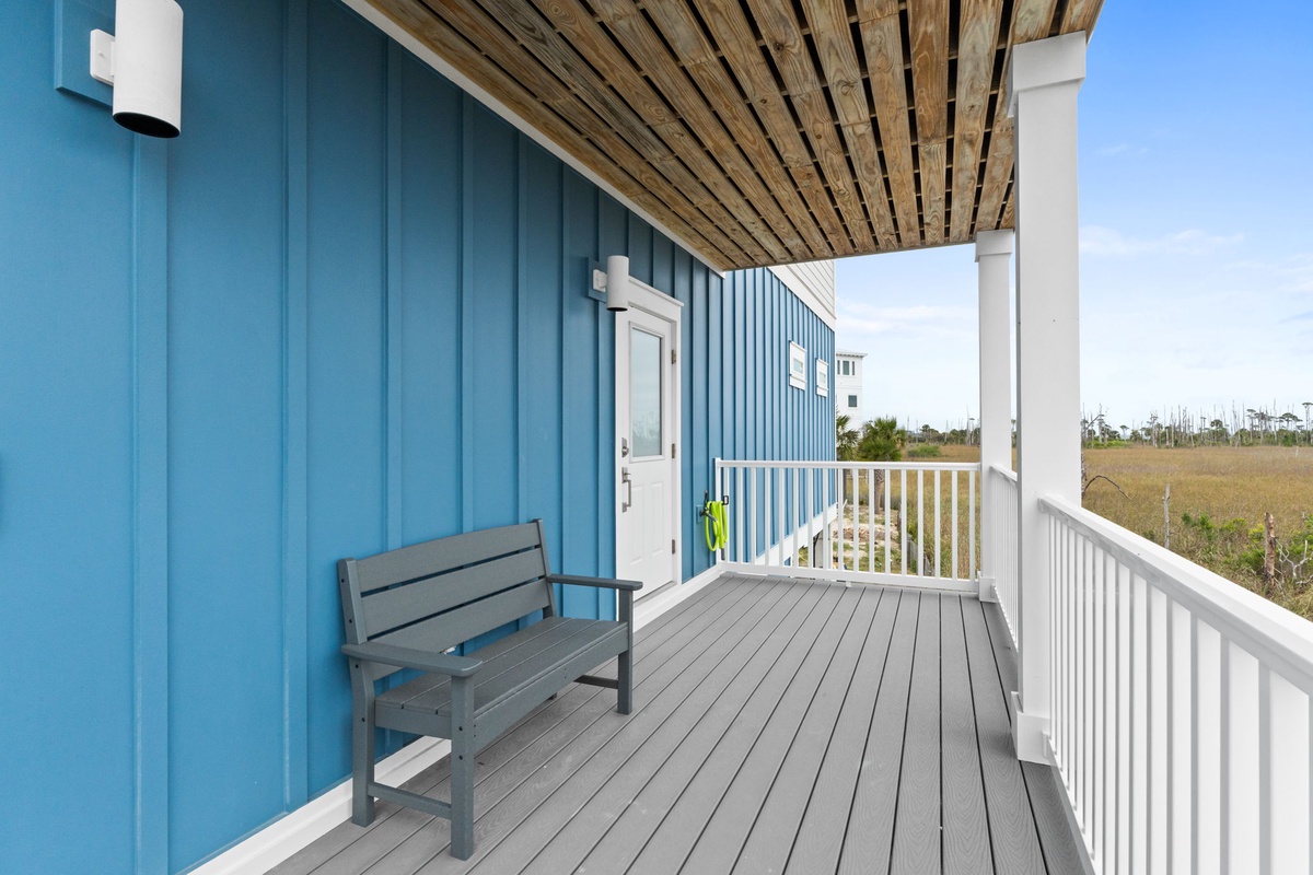 Your private covered balcony offers peaceful moments with comfortable seating and stunning natural landscape views stretching into the distance.