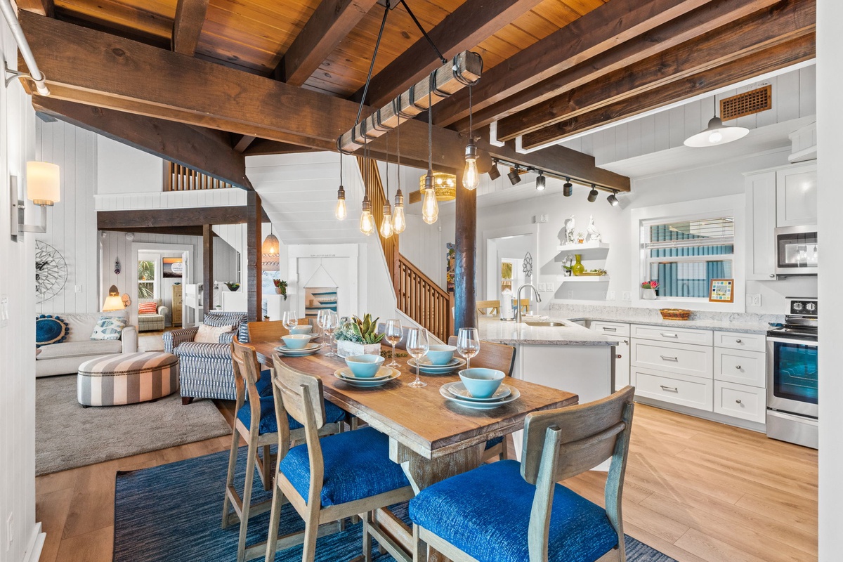 You'll love gathering around this stunning farmhouse table beneath soaring wood beams. The open-concept layout flows seamlessly from dining to kitchen to living space, perfect for making memories with your group.
