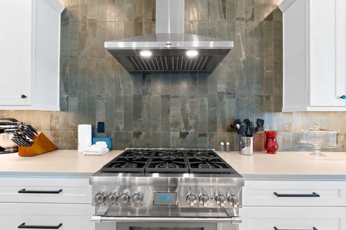 Your fully equipped kitchen features a professional-grade gas range and sleek stainless steel hood, perfect for creating memorable meals during your stay.