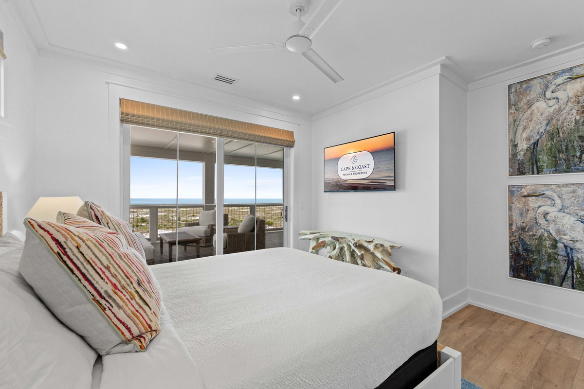 Wake up to breathtaking ocean views through your private balcony doors. Crisp linens, modern art, and a ceiling fan ensure your comfort in this serene coastal retreat.