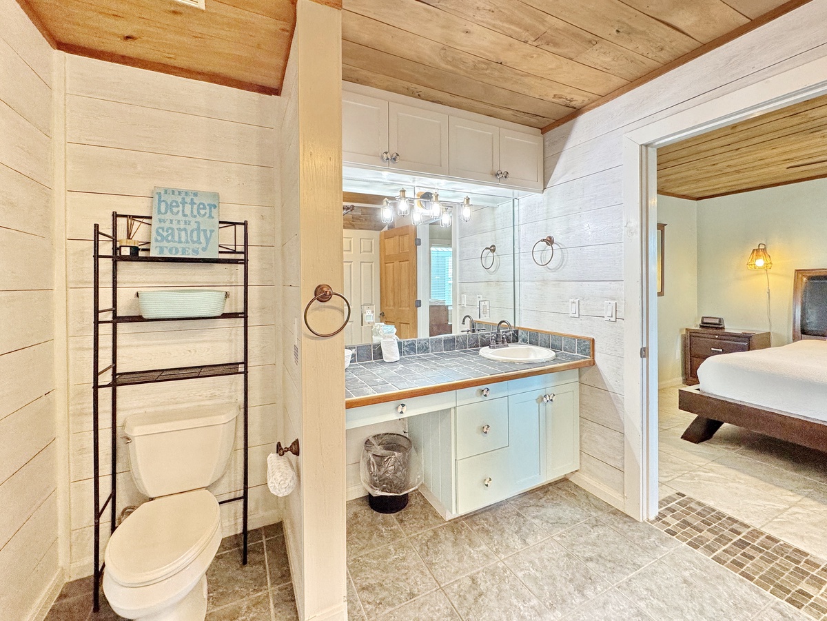 Your coastal-themed bathroom features a stunning tile vanity, spacious shower, and charming beachy details under beautiful wood beam ceilings.